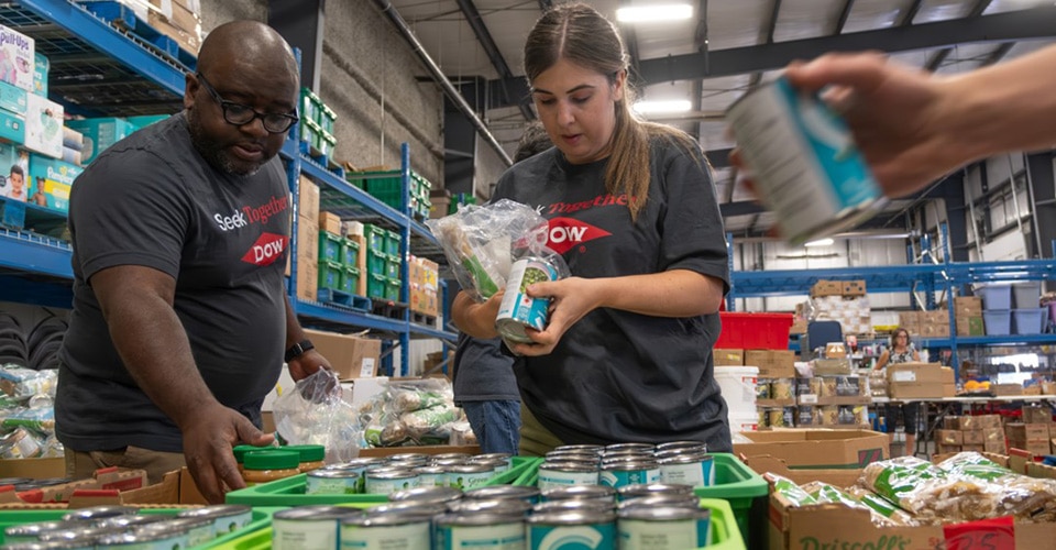 Dow team members pack food items for distribution