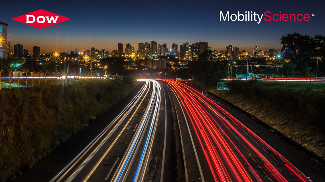 Image of cityscape at night with neon lights shining across a highway